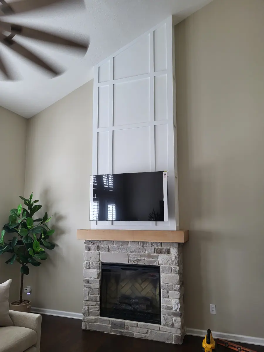 Custom board-and-batten fireplace surround with solid wood mantel in a Columbus living room